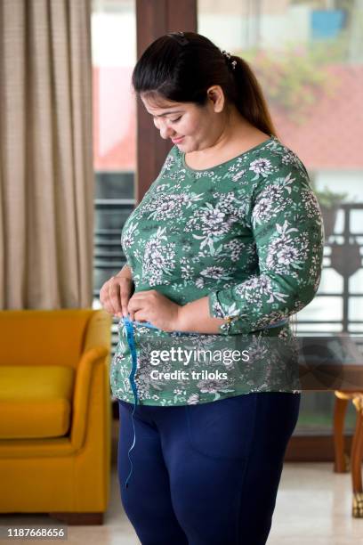 obese woman measuring her belly - woman waist up stock pictures, royalty-free photos & images