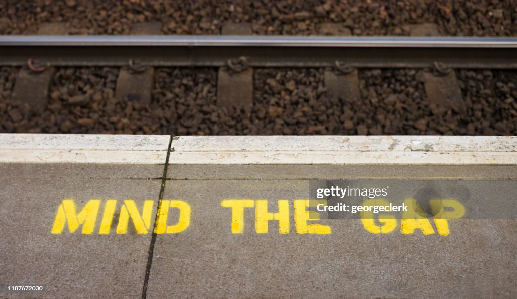 Let op de kloof waarschuwing teken op treinstation platform