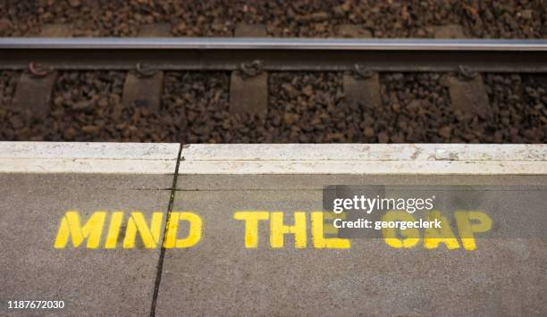 mind the gap warning sign on train station platform - london-underground-station-sign stock pictures, royalty-free photos & images