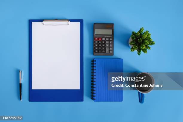 financial planning. clipboard and calculator on blue desk. - calculator top view stock-fotos und bilder