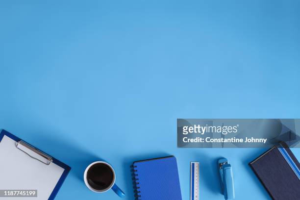 office supply items on blue work desk - office work flat lay stockfoto's en -beelden