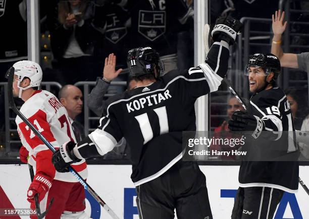 Alex Iafallo of the Los Angeles Kings celebrates his game winning goal with Anze Kopitar as Dylan Larkin of the Detroit Red Wings skate by during a...