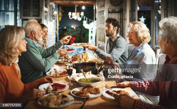 family having thanksgiving dinner. - evening meal stock pictures, royalty-free photos & images