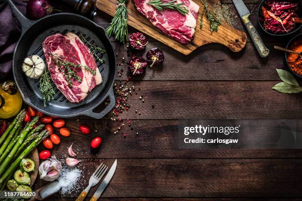 asando filetes de ternera y verduras en una parrilla de hierro con espacio de copia en la mesa - wooden board　food fotografías e imágenes de stock