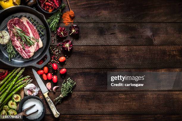 roasting a beef steak and vegetables on an iron grill with copy space on the table - food table edge stock pictures, royalty-free photos & images