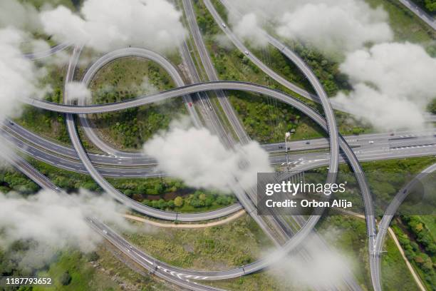 aerial photograph of a highway crossing with clouds - foggy road stock pictures, royalty-free photos & images