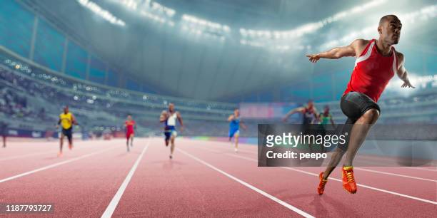 champion athlet gewinnt sprint-rennen wettbewerb in indoor-track-event - leichtathletik stock-fotos und bilder