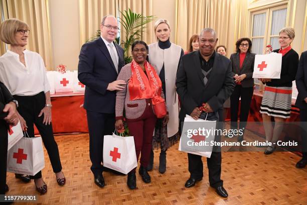 Prince Albert II of Monaco and Princess Charlene of Monaco pose with Monaco's residents during a Christmas gift-giving event at the headquarters of...