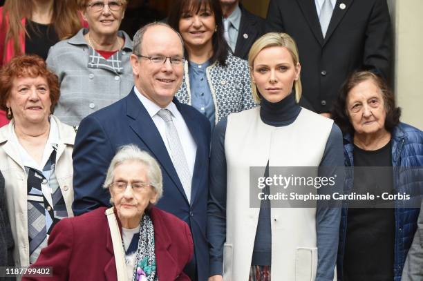 Prince Albert II of Monaco and Princess Charlene of Monaco pose with Monaco's residents during a Christmas gift-giving event at the headquarters of...