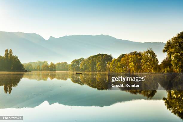 reflections at lake in the morning - austria stock pictures, royalty-free photos & images