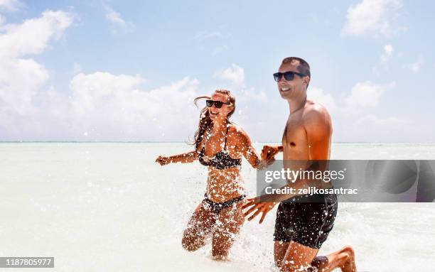 coppia rilassarsi sulla spiaggia godere di un bellissimo mare sull'isola tropicale - zanzibar foto e immagini stock