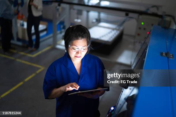 mature employee working and using machinery in industry - smart manufacturing stock pictures, royalty-free photos & images