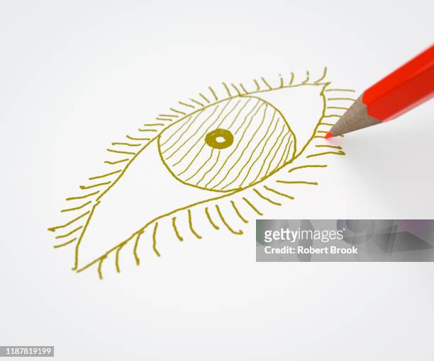 red pencil drawing an eye in a different colour - colorblind artist in full color stockfoto's en -beelden