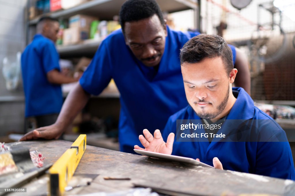 Colleagues using digital tablet and working in industry