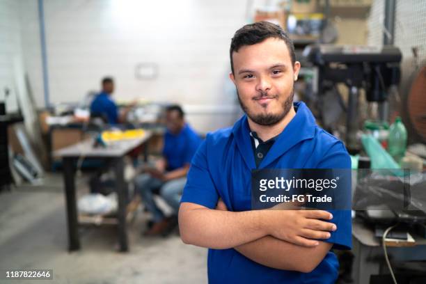 porträt lächelnder mitarbeiter für besondere bedürfnisse in der industrie - persons with disabilities stock-fotos und bilder