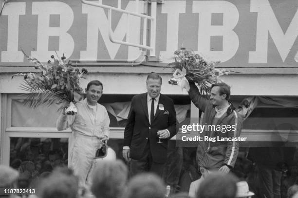 New Zealand racing drivers Bruce McLaren and Chris Amon with Ford CEO Henry Ford II on the podium after winning the 24 Hours of Le Mans, the 34th...