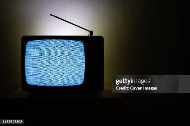 old vintage television isolated on dark background with no signal and grainy noise - voelspriet stockfoto's en -beelden