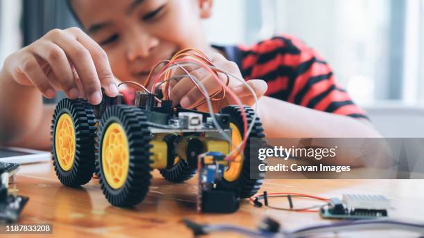 concentrated boy creating robot at lab. - remote controlled car stockfoto's en -beelden