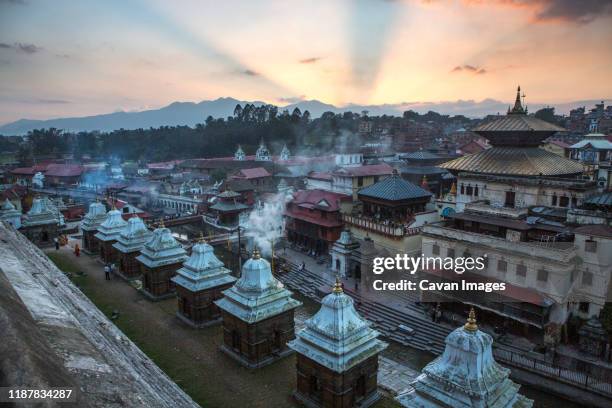 sunset and cremations at pashupatinath temple in kathmandu, nepal. - pashupatinath photos et images de collection