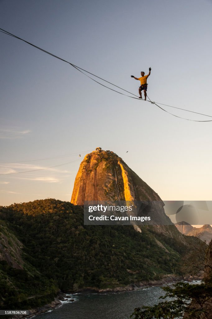 Slackliner walking on highline on beautiful sunset near Sugar Loaf