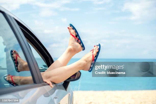 woman relaxing in a car on the beach - chinelo imagens e fotografias de stock