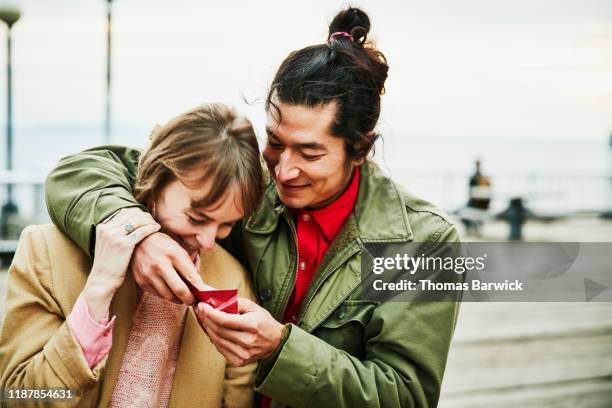 laughing couple embracing and sharing chocolate while on date - sharing chocolate stock pictures, royalty-free photos & images