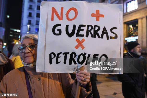 Protester holds a placard that says No Mas Guerras Por Petroleo during the demonstration. Hundreds of people gathered at Callao square in Madrid to...