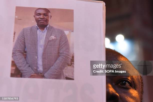 An Equatorial Guinea national holds a placard during the protest. Hundreds of people gathered at Callao square in Madrid to mark the International...