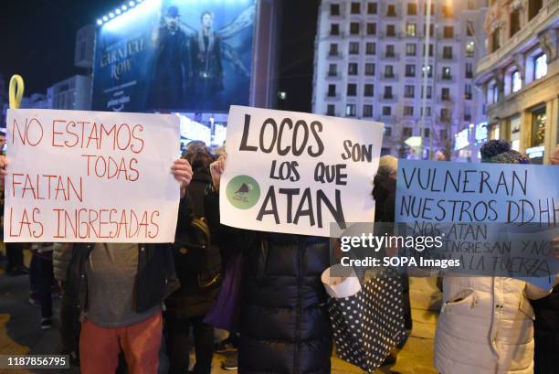 Demonstrators hold placards during the protest. Hundreds of people gathered at Callao square in Madrid to mark the International Human Rights Day.