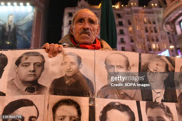 Protester holds a banner with pictures of people who went missing during the Spanish dictatorship of Francisco Franco . Hundreds of people gathered...