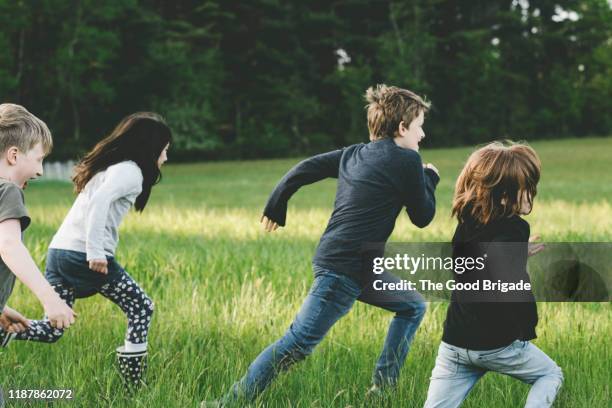 children running through grassy field - kids all ages stock pictures, royalty-free photos & images