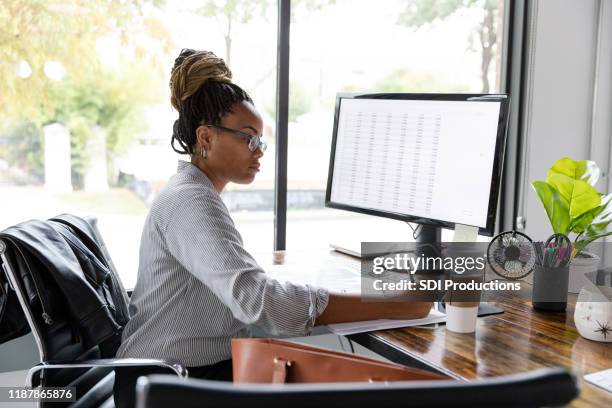 drukke zakenvrouw concentreert zich tijdens het werken bij haar bureau - stationery elegant stockfoto's en -beelden