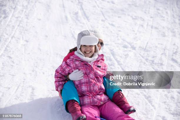 extatisk flicka glidande på snö med en vän - downhill bildbanksfoton och bilder