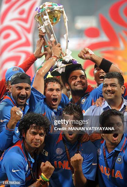 Indian cricketers celebrate with the trophy after beating Sri Lanka in the ICC Cricket World Cup 2011 final match at The Wankhede Stadium in Mumbai...