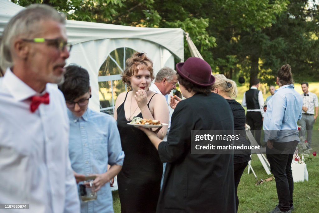 Gente recibiendo comidas de un camión de comida en una boda.