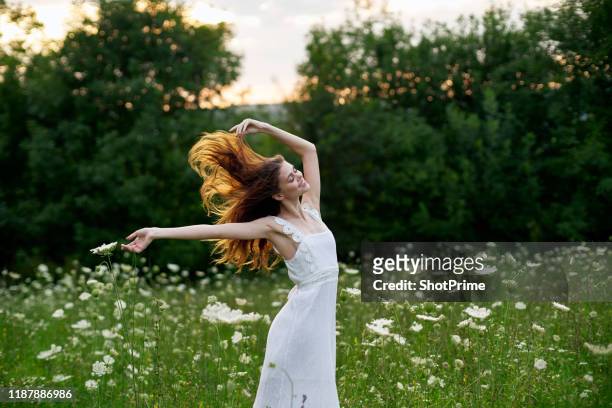 young woman with red hair in beautiful white dress outdoors - european spring foto e immagini stock
