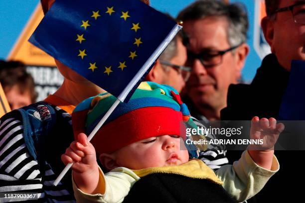 Liberal Democrat supporter's baby holds an EU flag as they wait for the arrival of Britain's Liberal Democrat leader Jo Swinson at a general election...