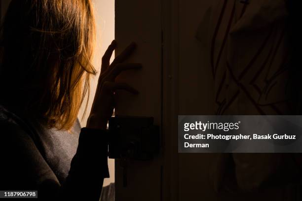 someone rings doorbell in the middle of the night and a woman opens the door - türklingel stock-fotos und bilder