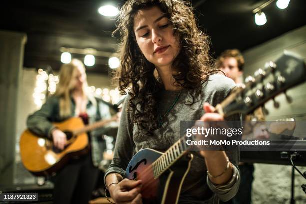 young rock band writing music together - mandolino foto e immagini stock