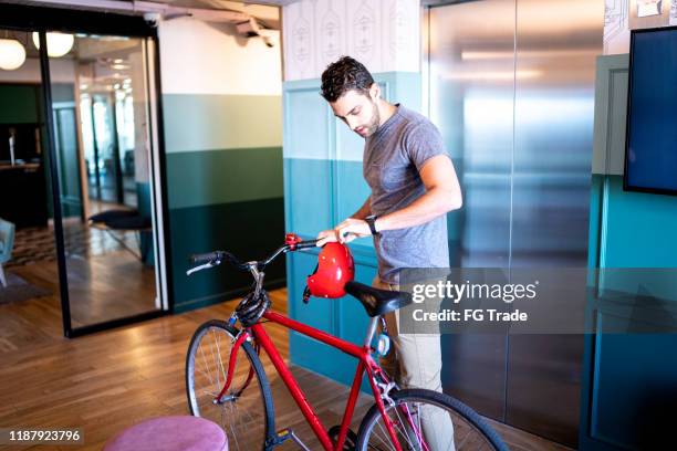 young businessman entering with bicycle at modern office - leaving office stock pictures, royalty-free photos & images