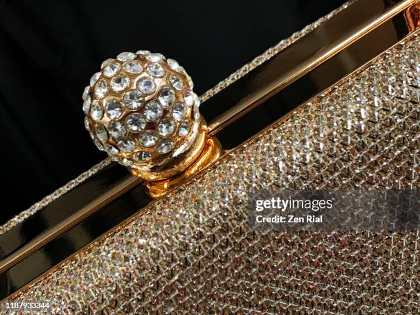 close-up of a fancy rhinestone-covered snap lock detail on a gold colored elengant purse - bolsa metálica imagens e fotografias de stock