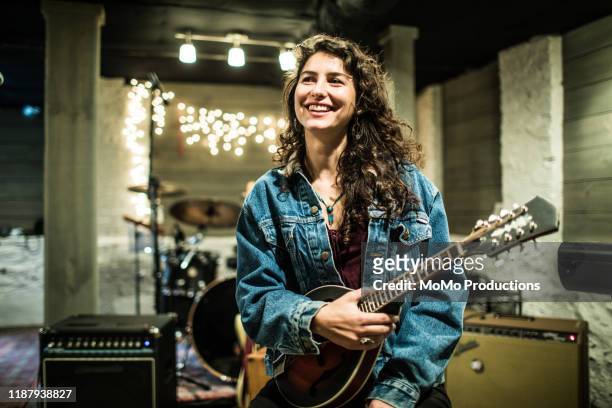 portrait of female mandolin player smiling - musiker stock-fotos und bilder