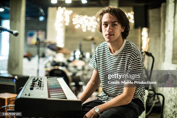 portrait of young man sitting at keyboard - darstellender künstler stock-fotos und bilder