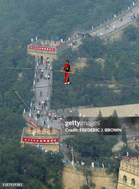 Tightrope walker Zhang Sheng Ling from Henan Province walks on a wire strung 100 metres above the Great Wall of China at Badaling, 18 September 2002,...