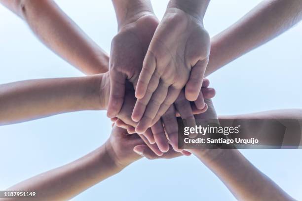 low angle view of children hands clasped - hands together stock pictures, royalty-free photos & images