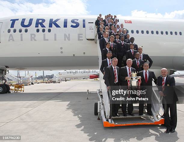 Sir Alex Ferguson of Manchester United poses with the Premier League trophy, the Manchester United squad and staff from Turkish Airlines at...