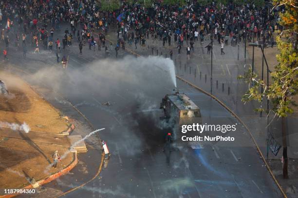 Demonstrators are sprayed by security forces with a water cannon during a protest against Chile's government in Santiago, Chile November 4, 2019.