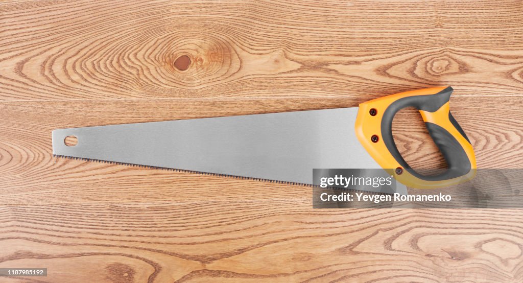 Saw on wooden background