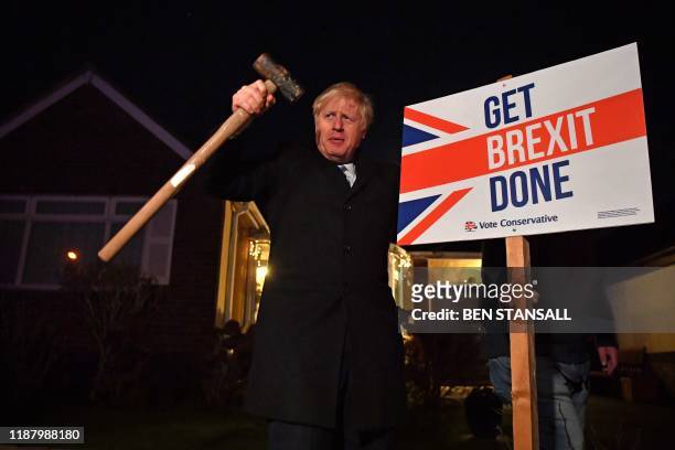 Britain's Prime Minister and Conservative party leader Boris Johnson poses after hammering a "Get Brexit Done" sign into the garden of a supporter,...