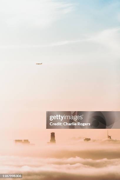 downtown la in sunrise fog with plane overhead - hollywood hills stock pictures, royalty-free photos & images